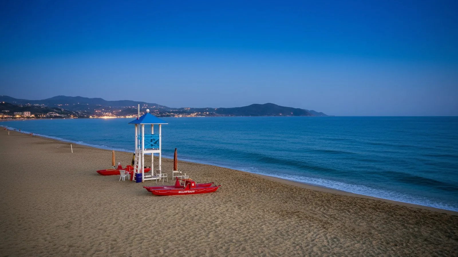 La spiaggia sabbiosa di Capaccio Paestum all'imbrunire, con la torretta di salvataggio e la costa del Golfo di Salerno sullo sfondo